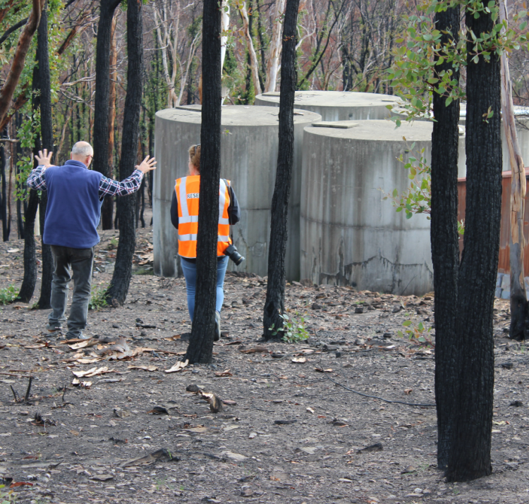 An interviewee shows a researcher the impact the bushfire had on his property. Photo: NSW Rural Fire Service.