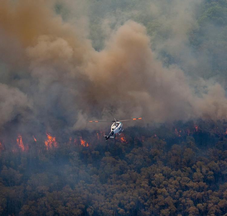 Firefighting helicopter flying over the 2018 Stradbroke bushfires. Photo: QFES