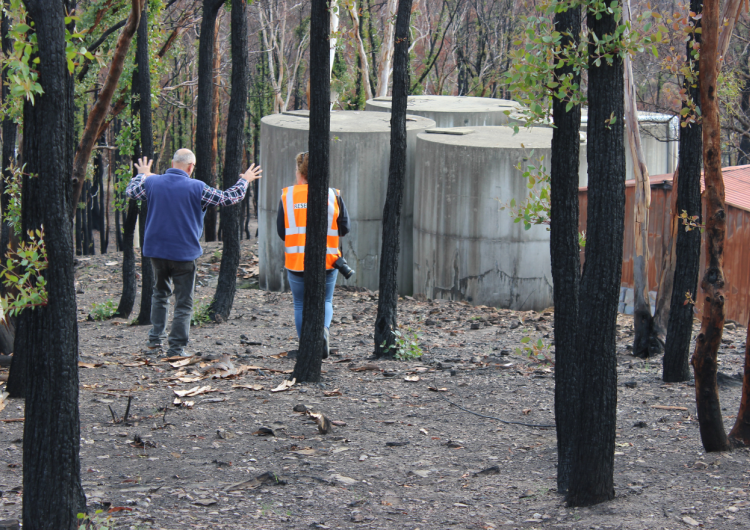 An interviewee shows a researcher the impact the bushfire had on his property. Photo: NSW Rural Fire Service.