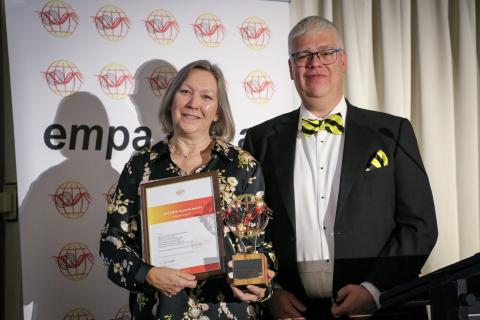 Mel Taylor holding an award standing next to and EMPA NZ chair Sam Rossiter-Stead