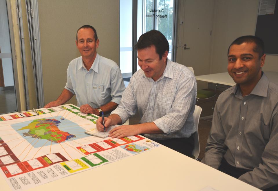 Fire managers consulting at a fire seasonality map at a seasonal bushfire outlook workshop. Photo: Bushfire and Natural Hazards CRC