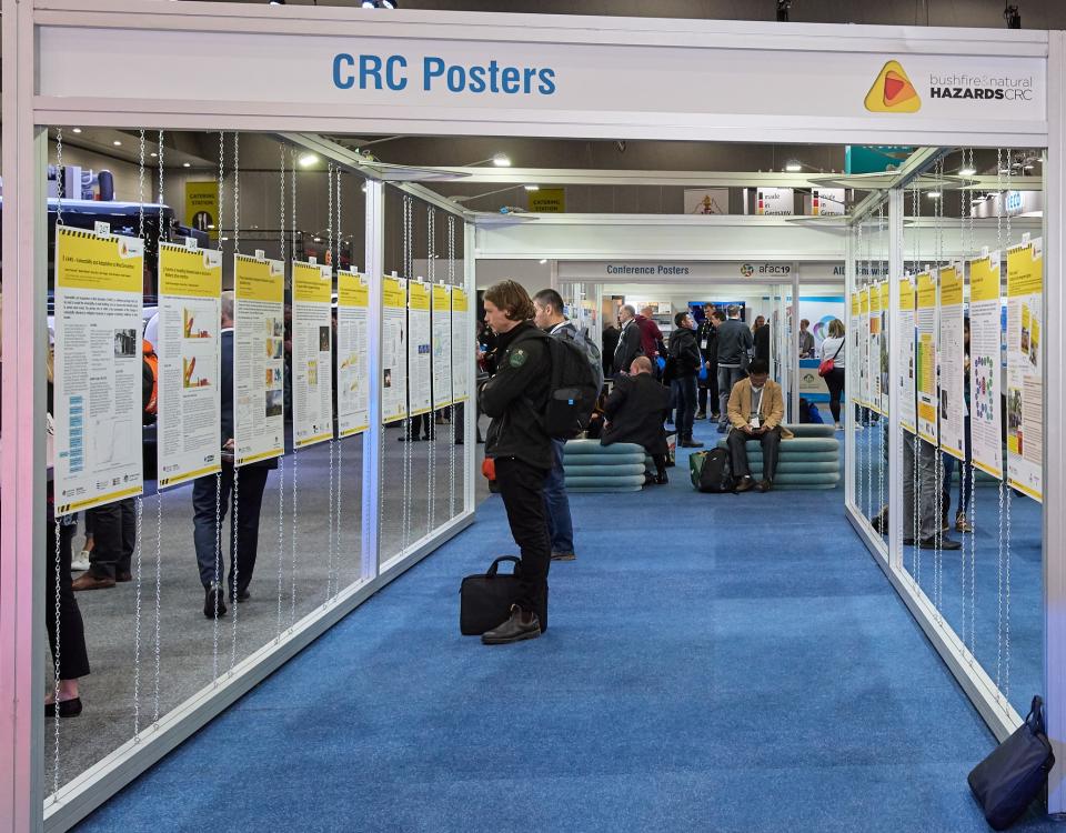 A conference participant views CRC posters in the exhibition hall at AFAC19 in Melbourne.