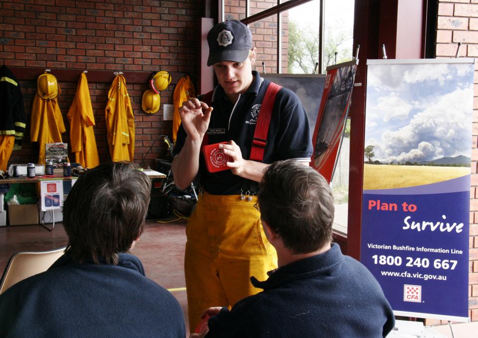 A fireman discusses a fire plan to locals. Photo: Country Fire Authority. 